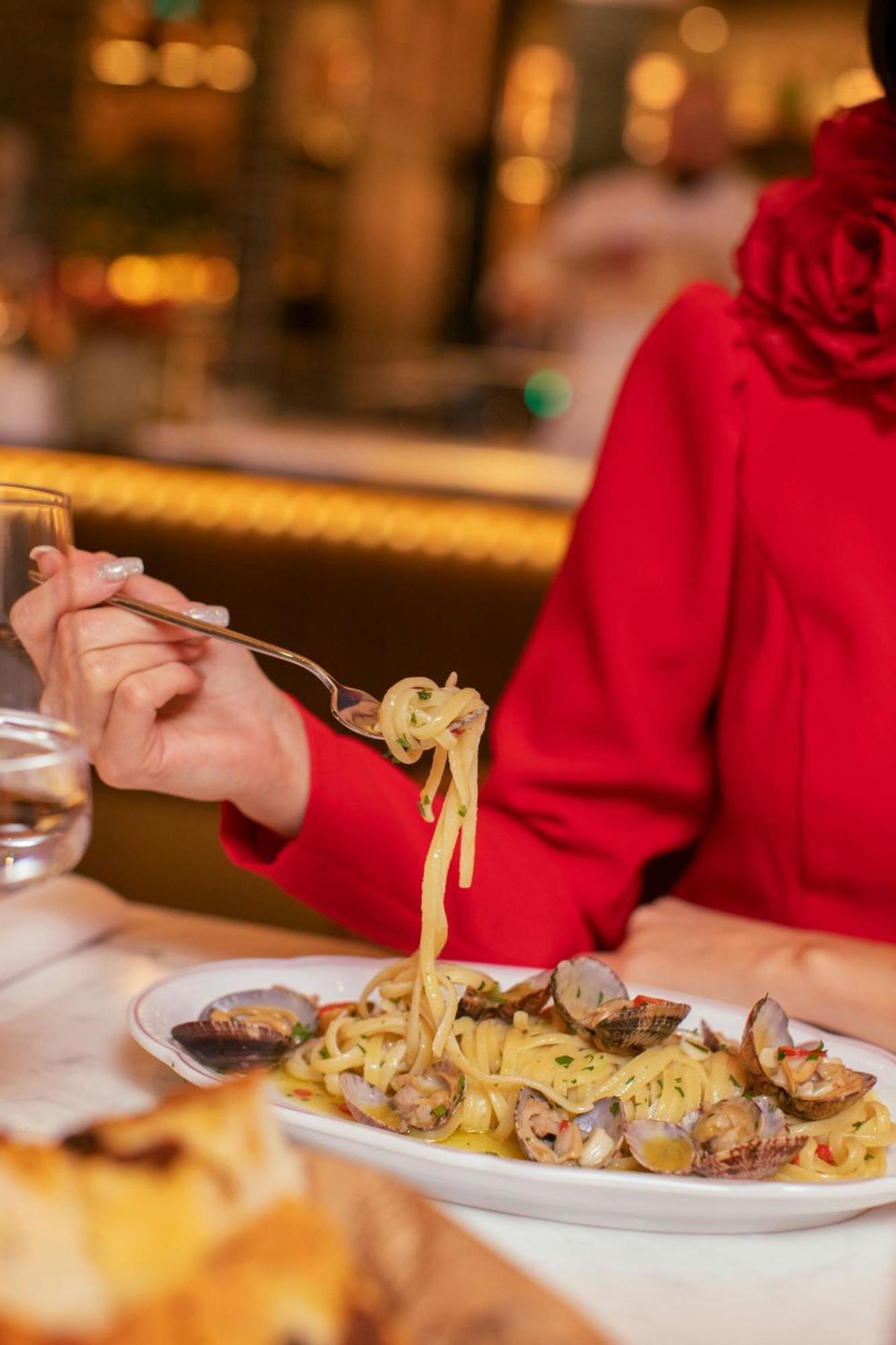 Sheraton Grand Warsawa Bagian luar foto A woman eating pasta